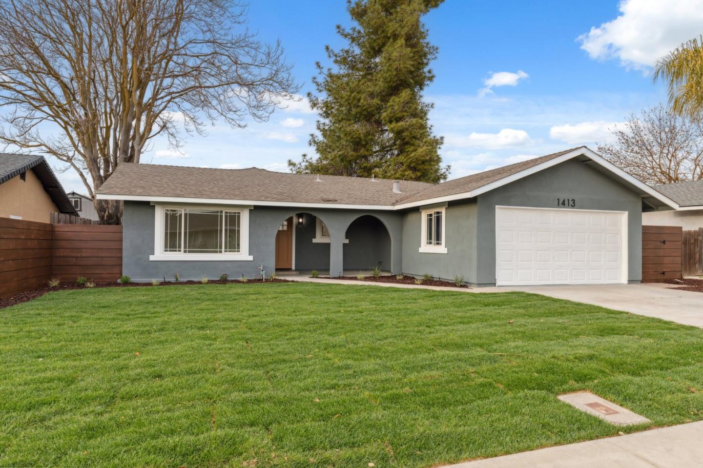 1413 Clevenger Drive Modesto, CA 95356 - Photo 2 of 37 a front view of a house with a garden