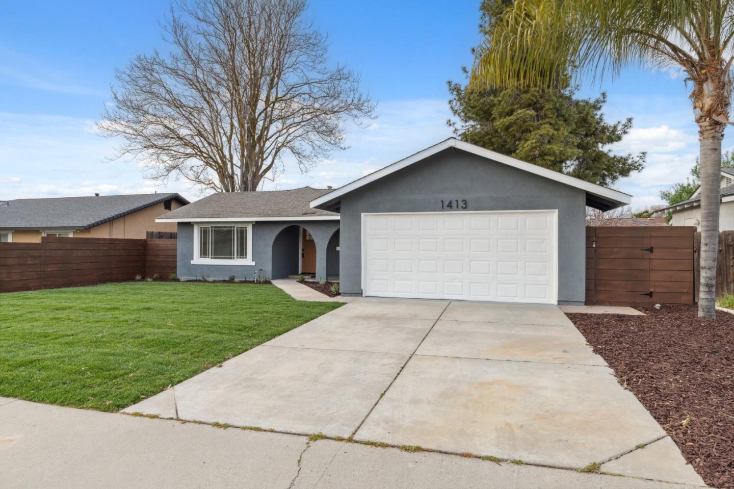 1413 Clevenger Drive Modesto, CA 95356 - Photo 3 of 37 a front view of a house with a yard and garage
