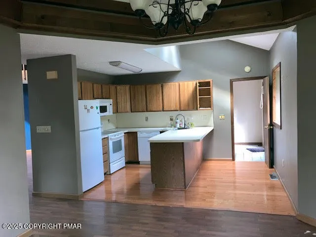 a kitchen with a sink cabinets and wooden floor