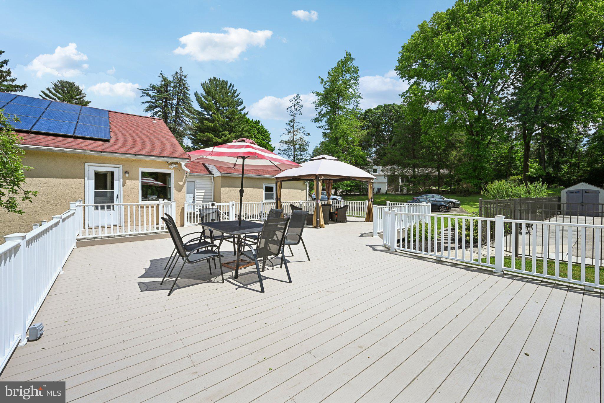 1240 Gilbert Road Jenkintown, PA 19046 - Photo 61 of 73 a view of a roof deck with table and chairs under an umbrella with wooden floor