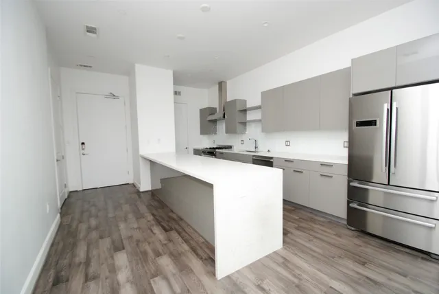 a kitchen with a refrigerator sink and cabinets