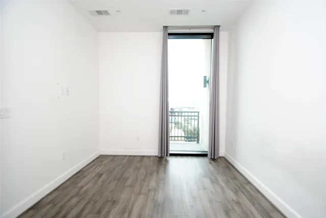 an empty room with wooden floor and a window