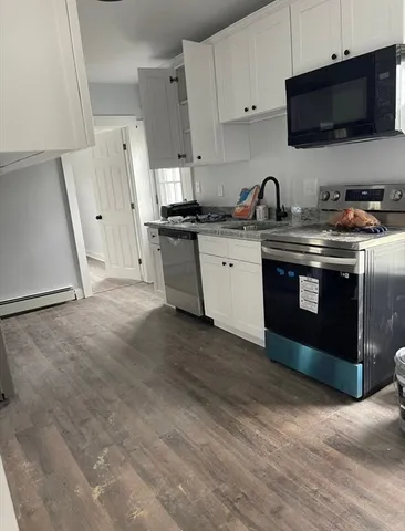 a kitchen with stainless steel appliances granite countertop a stove a sink and a microwave