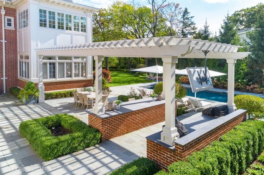 660 Prospect Avenue Winnetka, IL 60093 - Photo 72 of 77 a view of a patio with couches table and chairs under an umbrella