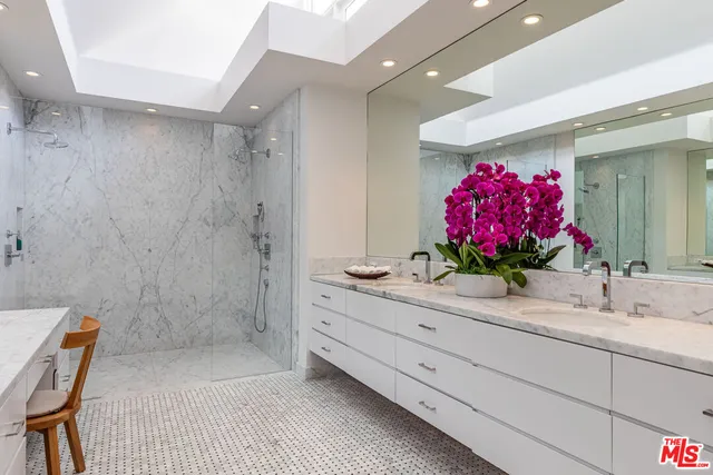 a bathroom with a granite countertop sink a mirror and a shower