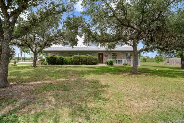 a front view of a house with yard and green space