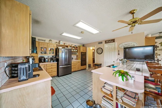 a kitchen with stainless steel appliances granite countertop a refrigerator and a stove top oven