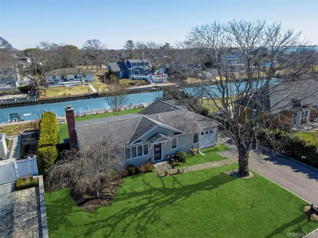 a view of a house with a big yard and large trees