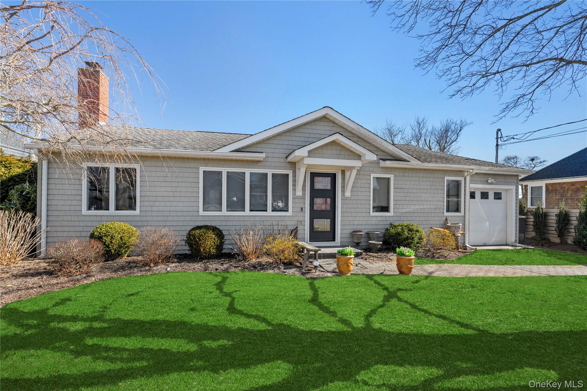 21 Tarpon Road East Quogue, NY 11942 - Photo 2 of 15 a front view of a house with garden and porch