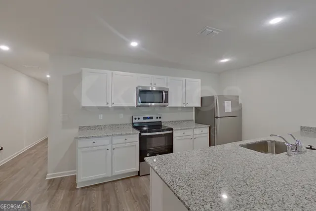 a kitchen with stainless steel appliances granite countertop a sink stove and refrigerator