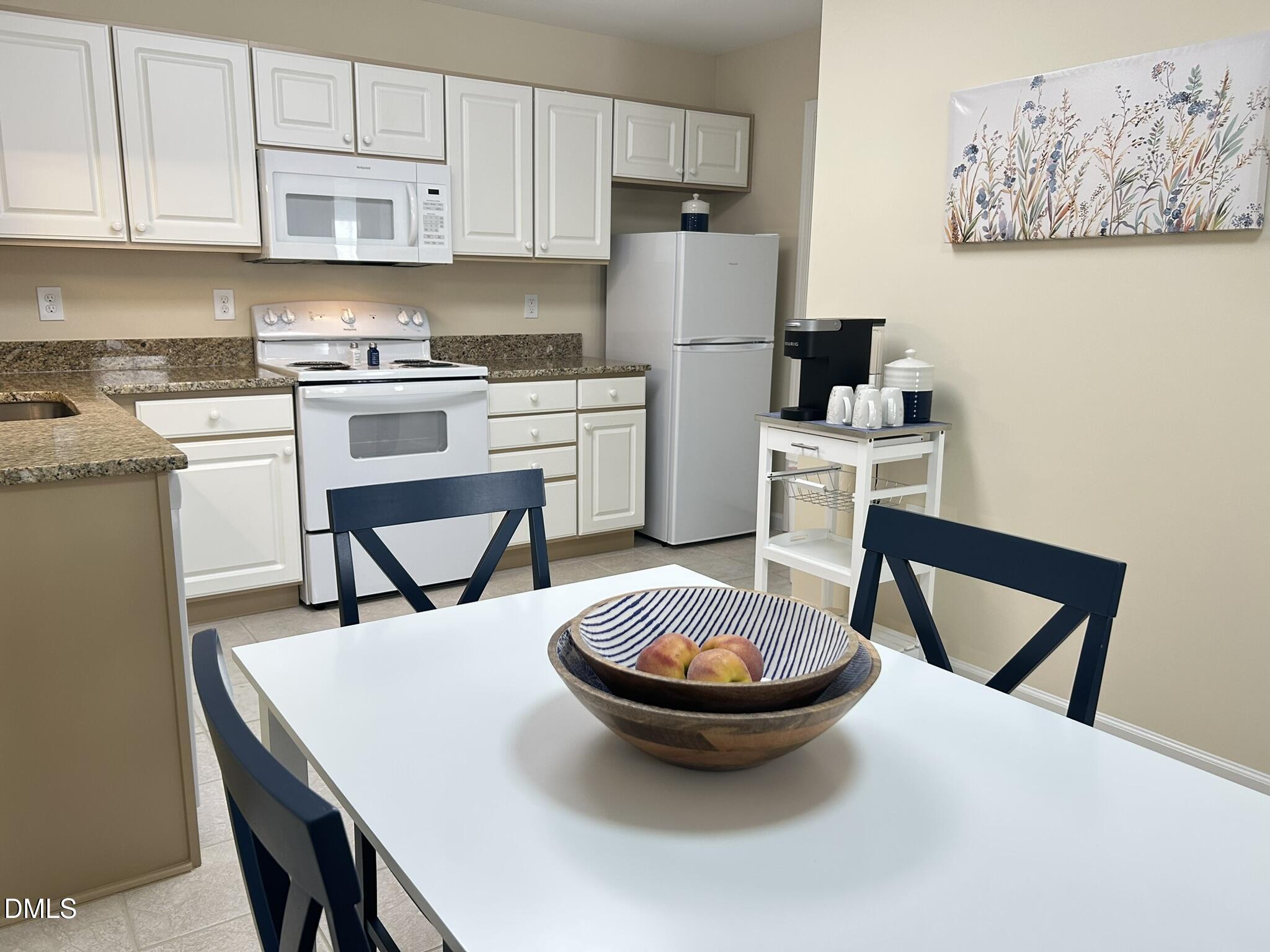 2510 Friedland Place, Unit 102 Raleigh, NC 27617 - Photo 8 of 42 a kitchen with a table chairs and cabinets