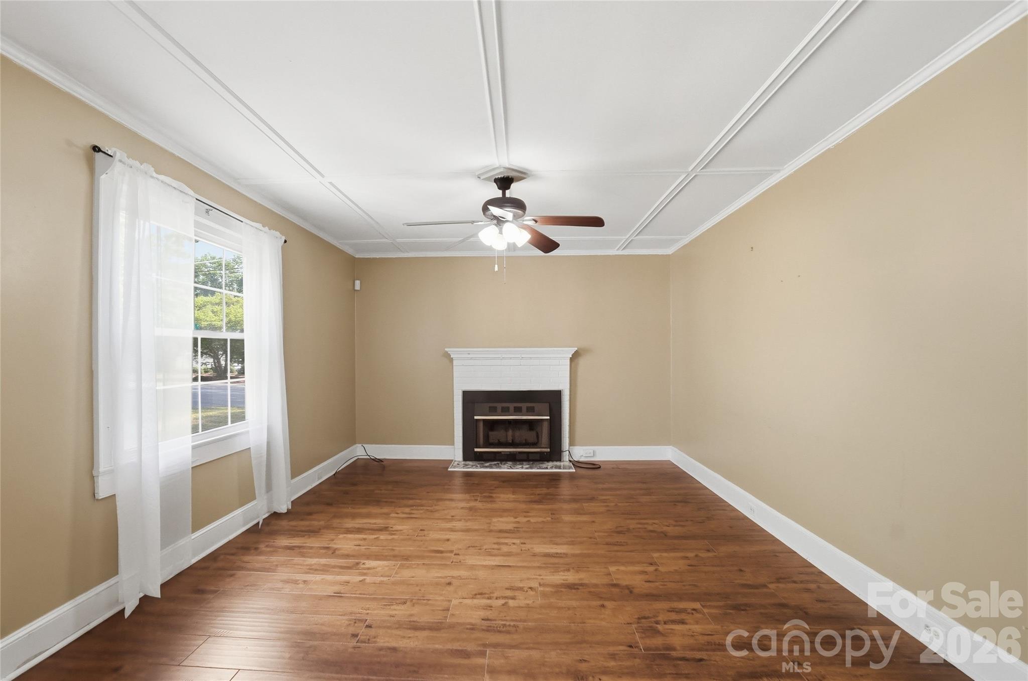 208 Jackson Terrace Clover, SC 29710 - Photo 11 of 30 an empty room with wooden floor fireplace and windows