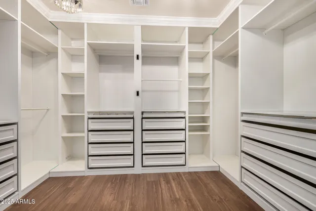 an empty room with wooden floor and ceiling fan