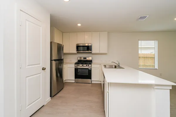 a kitchen with a refrigerator a stove top oven a sink and dishwasher
