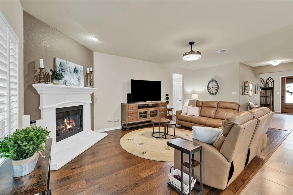 1701 Meadow Ranch Road McKinney, TX 75071 - Photo 10 of 40 a living room with furniture a fireplace and a flat screen tv
