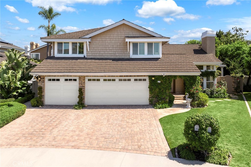 a front view of a house with a yard and potted plants