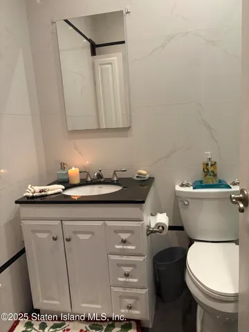 a bathroom with a toilet a sink and mirror