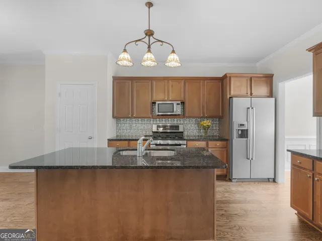 a view of an empty room with wooden floor fireplace and a window