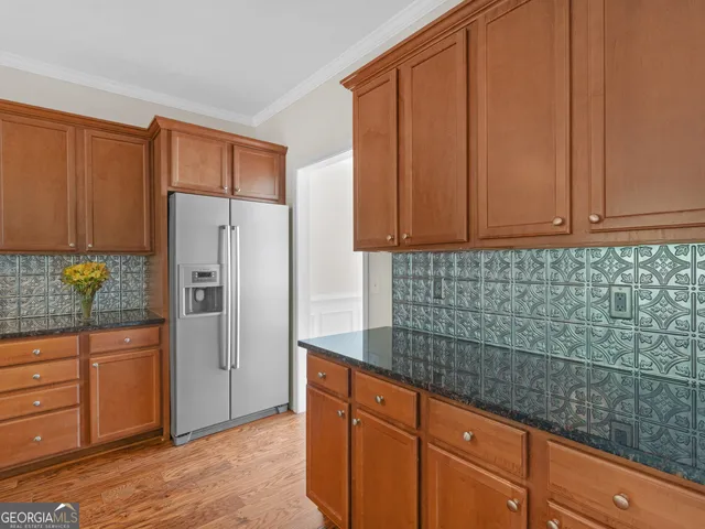 a kitchen with kitchen island granite countertop a stove a sink a center island and wooden floor