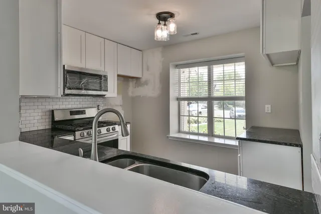 a kitchen with granite countertop a stove and a sink