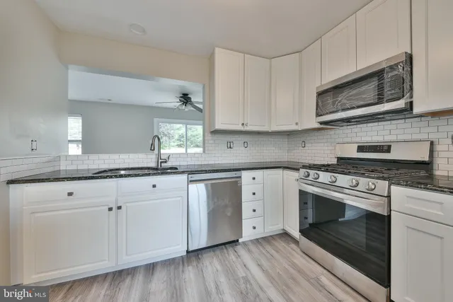 a kitchen with granite countertop white cabinets and white appliances