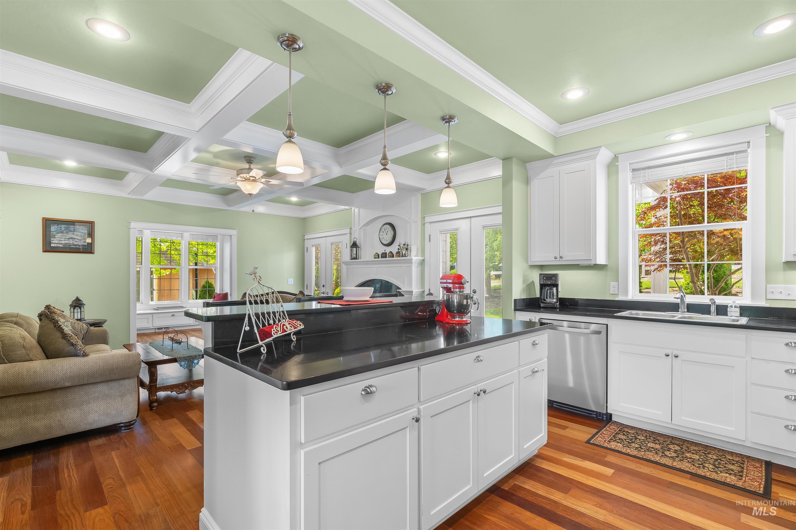 1617 Pine Cone Road Moscow, ID 83843 - Photo 11 of 44 Kitchen featuring a central island with dark countertop, white cabinetry, stainless steel appliances, wood-finish flooring, and a coffered ceiling