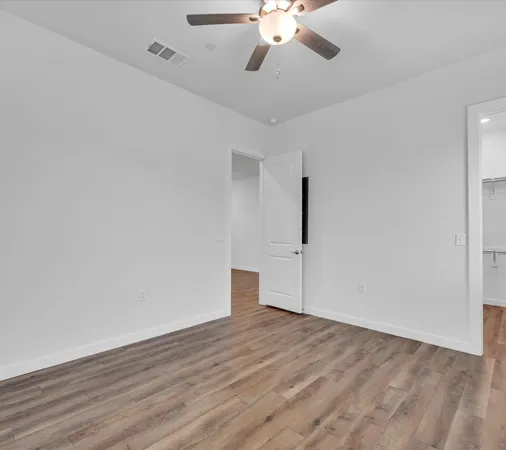 a view of an empty room with wooden floor