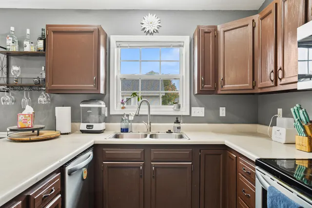 a kitchen with stainless steel appliances granite countertop a sink a stove and cabinets