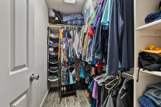a view of walk in closet with clothes and shoes