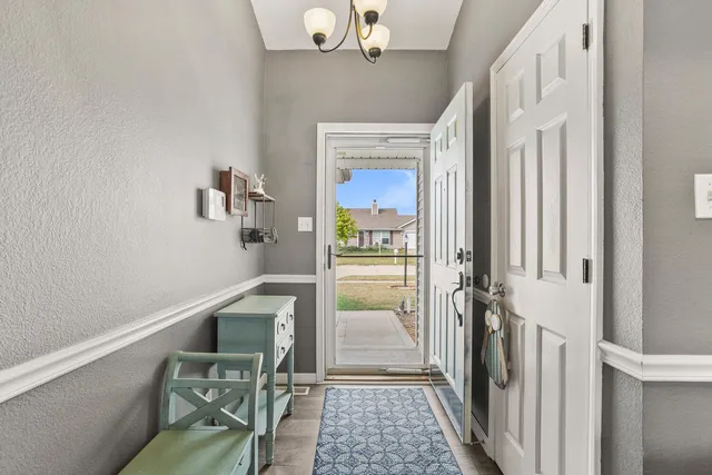 a hallway with dining area and chandelier