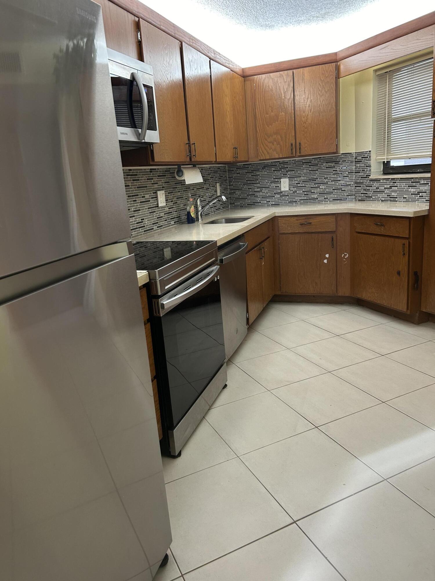 5701 Camino Del Sol, Unit 204 Boca Raton, FL 33433 - Photo 2 of 17 KITCHEN/QUARTZ COUNTERS/NEW APPLIANCES