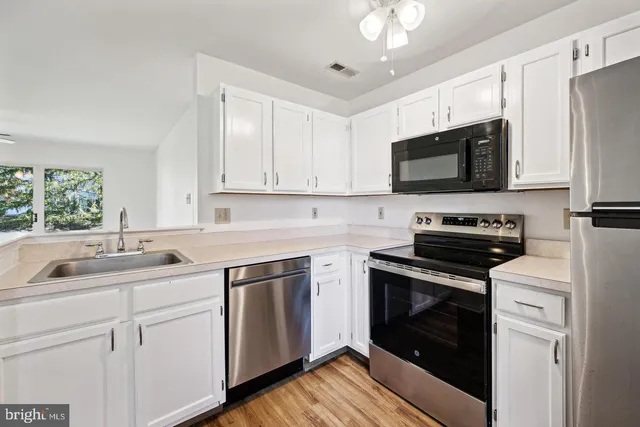 a kitchen with white cabinets stainless steel appliances and sink