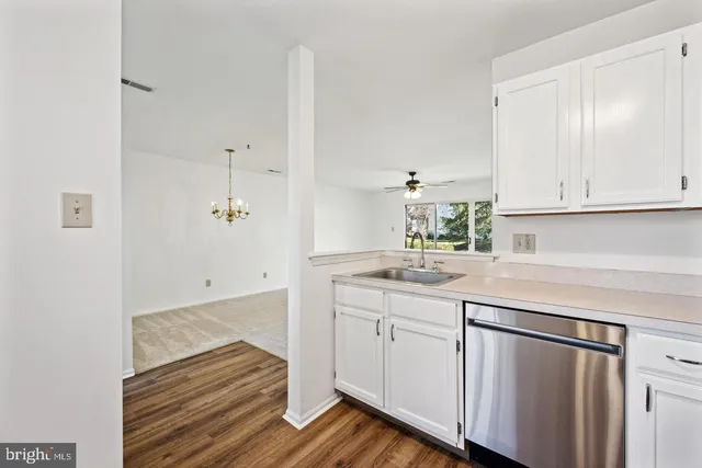 a kitchen with white cabinets and sink