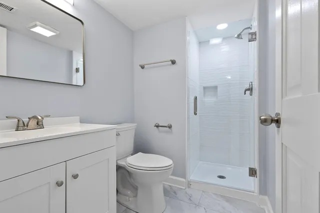 a bathroom with a sink a toilet and shower