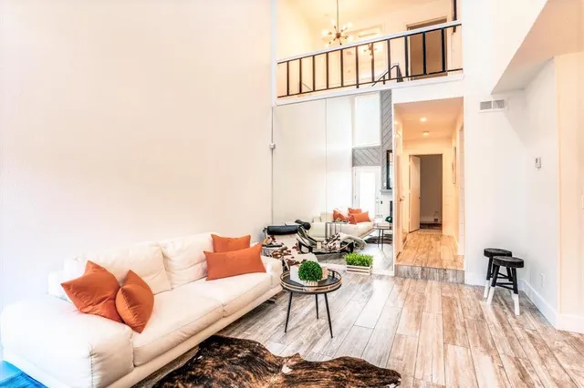 a living room with furniture and a wooden floor