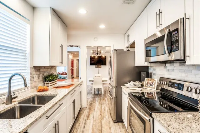 a kitchen with stainless steel appliances a stove sink microwave and cabinets
