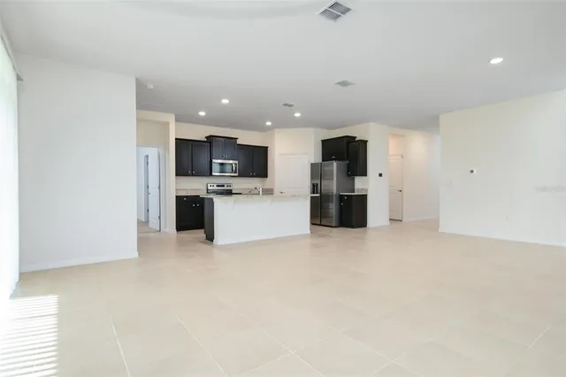 a view of kitchen with refrigerator stove microwave oven stove and kitchen island