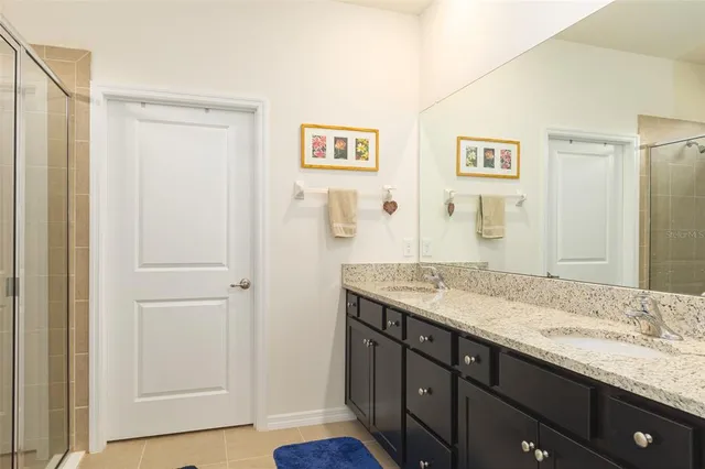 a en suite bathroom with a granite countertop sink