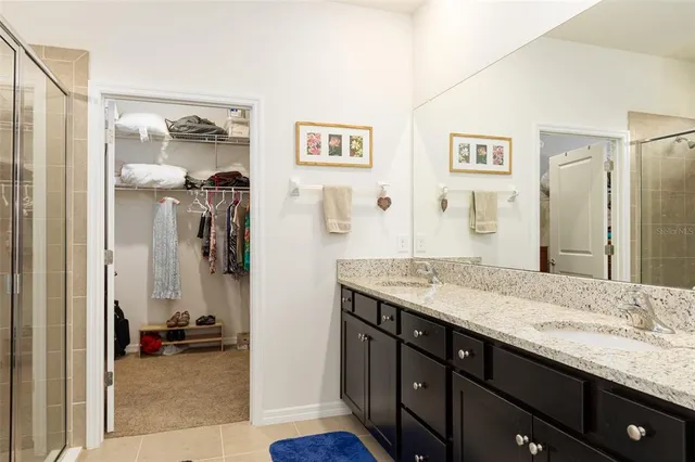 a en suite bathroom with a granite countertop sink mirror and shower