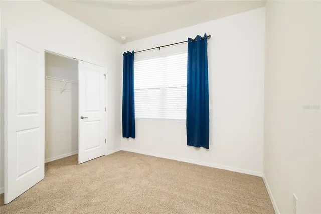 an empty room with windows and closet