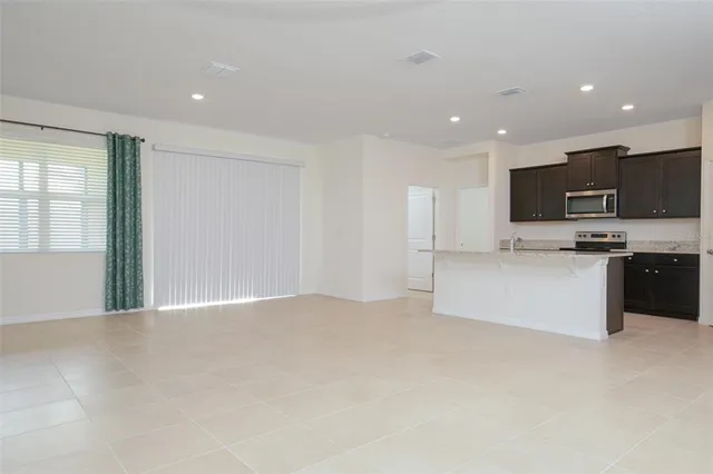 a view of kitchen with kitchen island sink and refrigerator