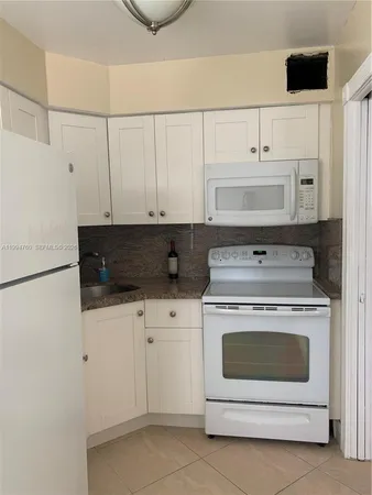 a stove top oven sitting inside of a kitchen