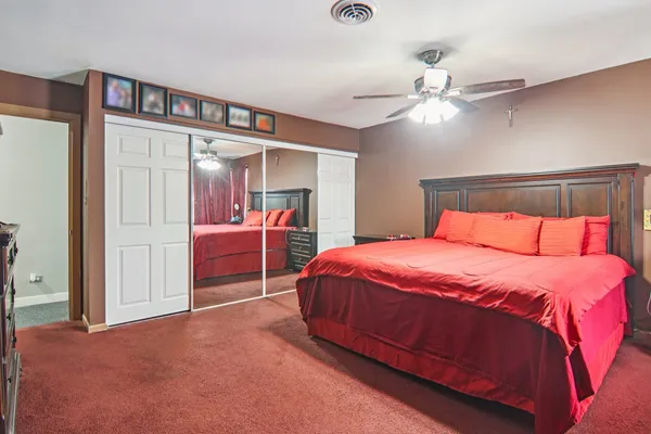 a bedroom with a large bed and a chandelier