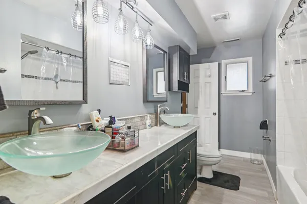 a bathroom with a granite countertop sink a toilet and a mirror