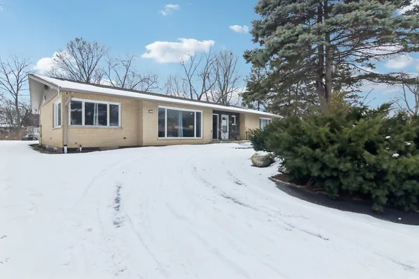 a view of a house with a yard covered in snow
