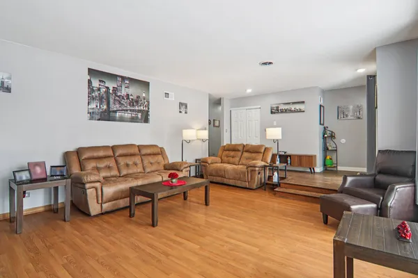 a living room with furniture and a wooden floor