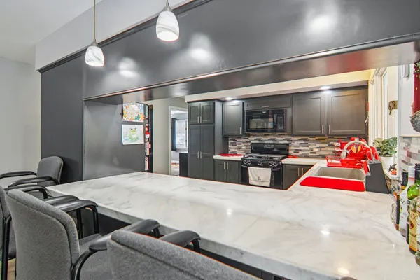 a kitchen with stainless steel appliances kitchen island granite countertop a refrigerator and a stove