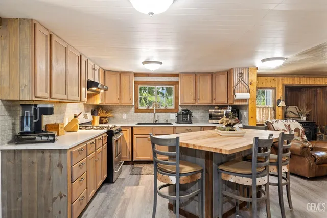 a kitchen with stainless steel appliances kitchen island granite countertop a table and chairs
