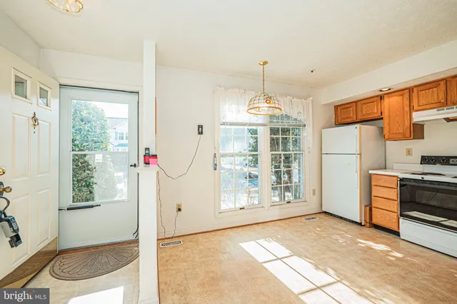 a view of a kitchen with fridge and wooden floor