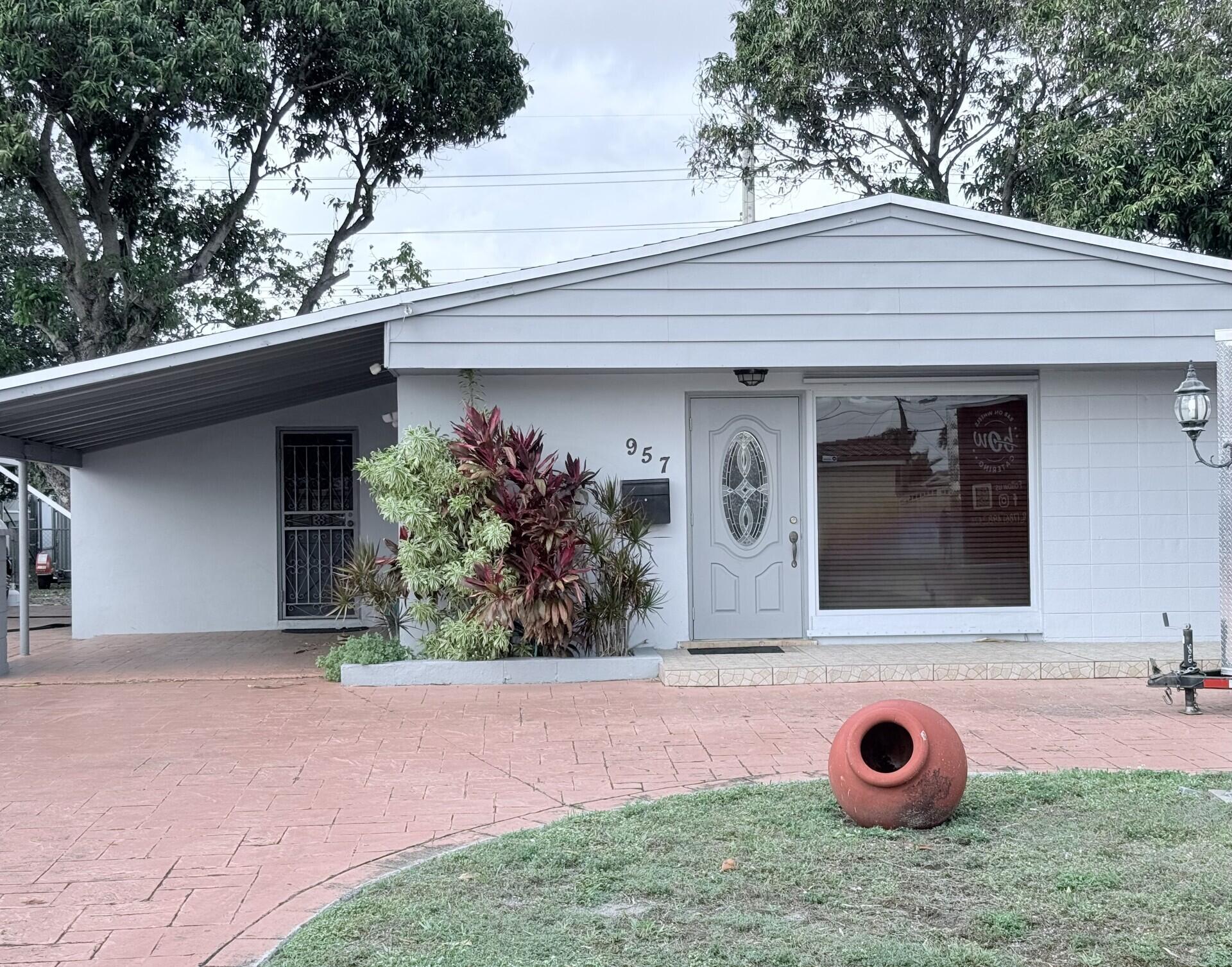 957 West 67th Street Hialeah, FL 33012 - Photo 1 of 15 a front view of a house with garden